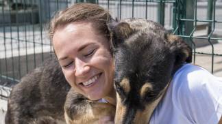 smiley-woman-playing-with-cute-dog-up-adoption